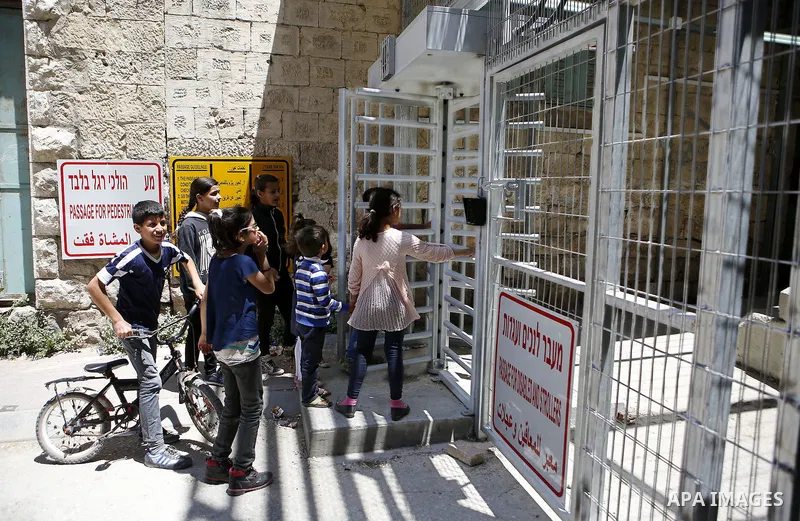 Palestinian children take part in a protest against the closure of Shuhada street to Palestinians in the West Bank city of Hebron on May 12, 2016. Photo by Wisam Hashlamoun