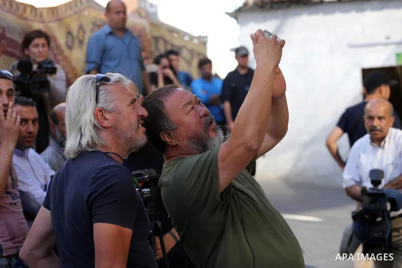 Chinese artist Ai Weiwei takes pictures with his phone as he works on a documentary film on refugees, in Nuseirat refugee camp in the central Gaza Strip on May 12, 2016. Photo by Mohammed Asad