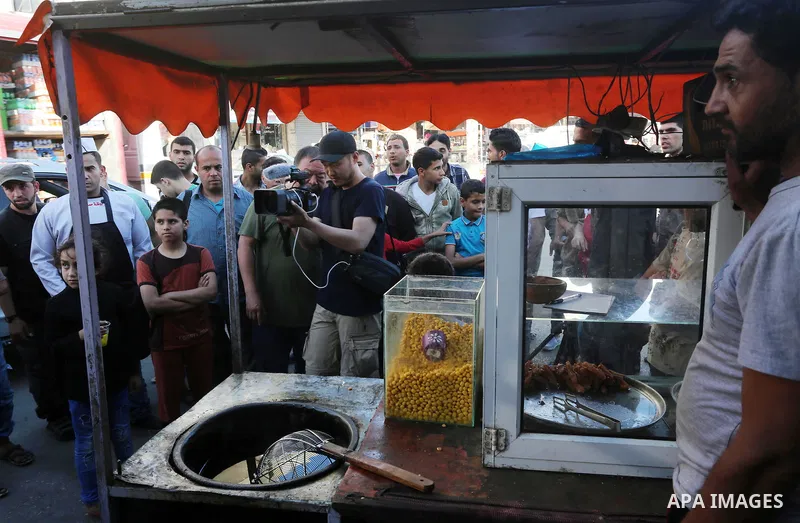 Chinese artist Ai Weiwei looks on as he meets with Palestinian during his work on a documentary film on refugees, in Nuseirat refugee camp in the central Gaza Strip on May 12, 2016. Photo by Mohammed Asad