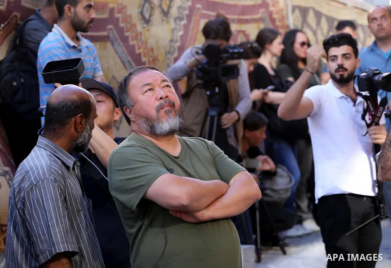 Chinese artist Ai Weiwei looks on as he works on a documentary film on refugees, in Nuseirat refugee camp in the central Gaza Strip on May 12, 2016. Photo by Mohammed Asad
