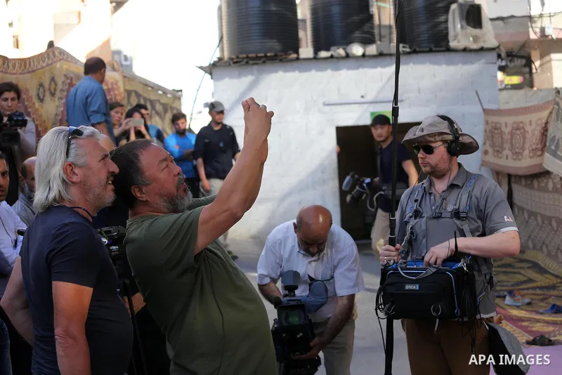 Chinese artist Ai Weiwei takes pictures with his phone as he works on a documentary film on refugees, in Nuseirat refugee camp in the central Gaza Strip on May 12, 2016. Photo by Mohammed Asad