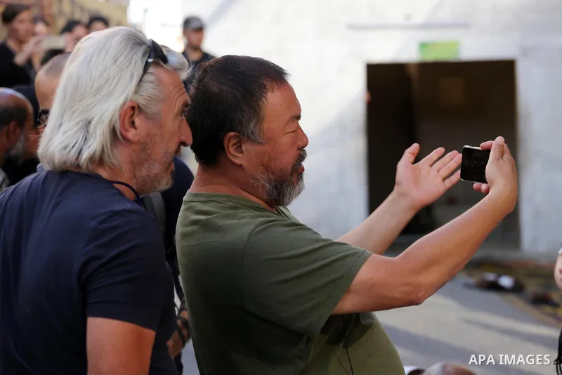 Chinese artist Ai Weiwei takes pictures with his phone as he works on a documentary film on refugees, in Nuseirat refugee camp in the central Gaza Strip on May 12, 2016. Photo by Mohammed Asad