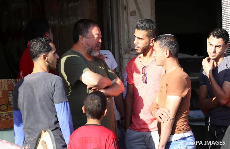 Chinese artist Ai Weiwei looks on as he meets with Palestinian during his work on a documentary film on refugees, in Nuseirat refugee camp in the central Gaza Strip on May 12, 2016. Photo by Mohammed Asad
