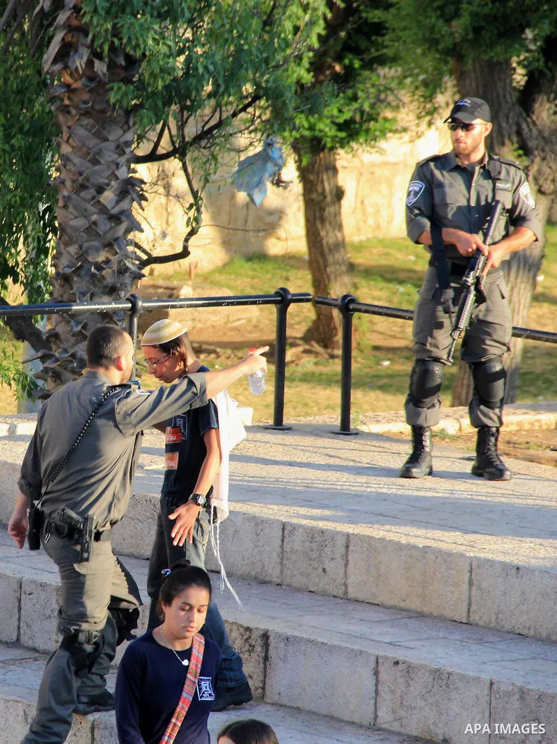 A member of Israeli security forces argues in front of Jewish settlers in front of the Damascus Gate, a main entrance to Jerusalem's Old City on May 12, 2016. Photo by Mahfouz Abu Turk
