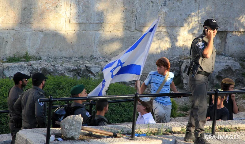 Israeli security forces stand garud in front of Jewish settlers near the Damascus Gate, a main entrance to Jerusalem's Old City on May 12, 2016. Photo by Mahfouz Abu Turk