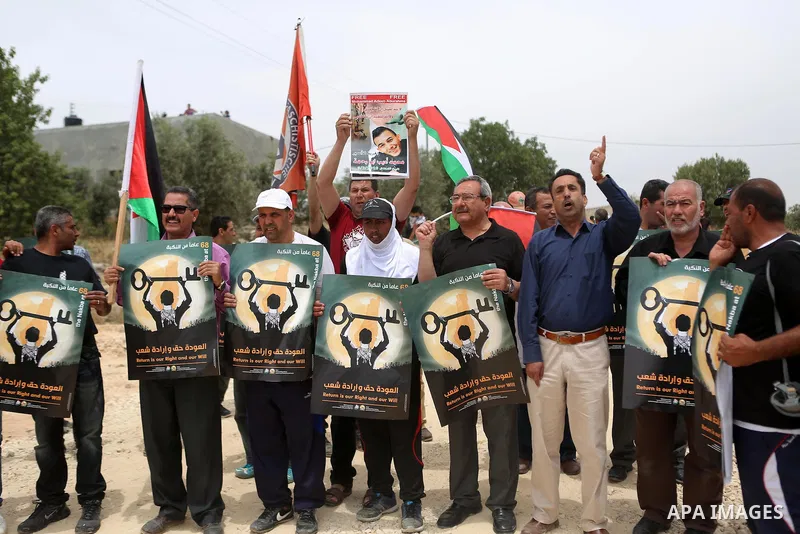 Palestinian protesters hold banners during a protest ahead of Nakba day, in the West Bank village of Bilin near Ramallah May 13, 2016. Photo by Shadi Hatem