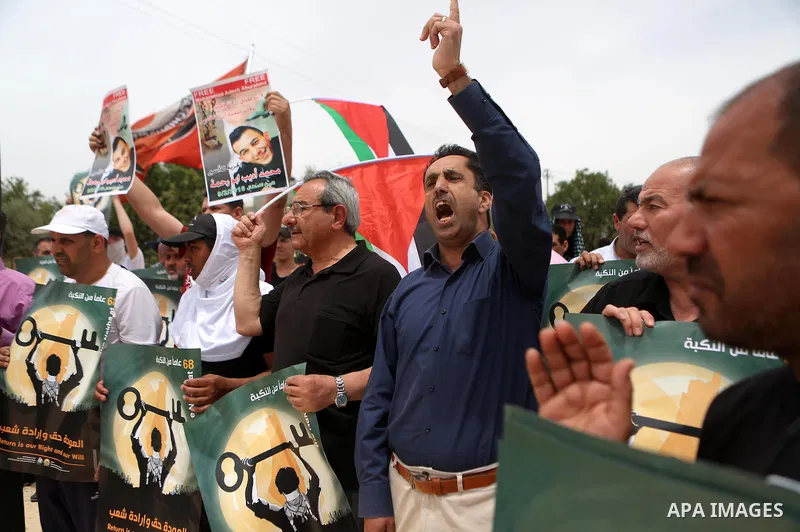 Palestinian protesters hold banners during a protest ahead of Nakba day, in the West Bank village of Bilin near Ramallah May 13, 2016. Photo by Shadi Hatem