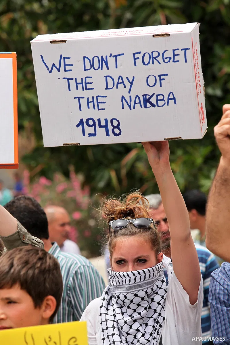 Palestinian protesters hold placards during a demonstration against the expropriation of Palestinian land by Israel, on May 13, 2016 in the village of Kfar Qaddum, near Nablus, in the occupied West Bank. Photo by Nedal E...