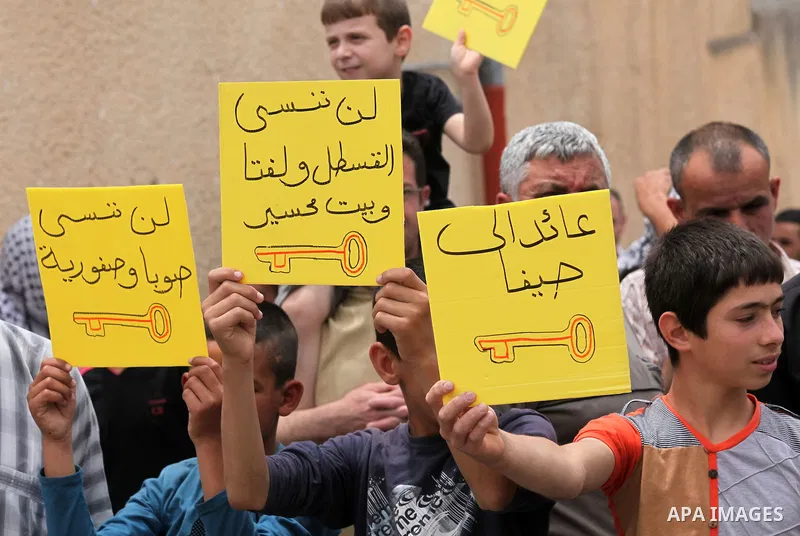 Palestinian protesters hold placards during a demonstration against the expropriation of Palestinian land by Israel, on May 13, 2016 in the village of Kfar Qaddum, near Nablus, in the occupied West Bank. Photo by Nedal E...