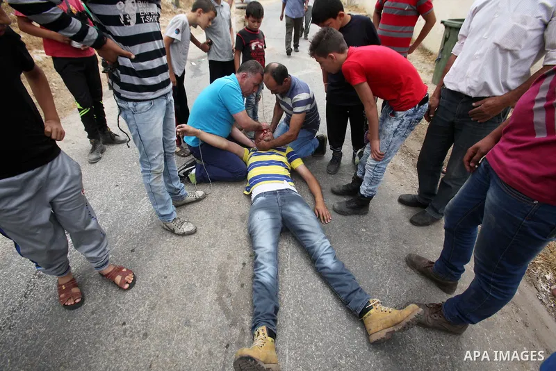 A wounded Palestinian is evacuated by protesters during clashes following a demonstration against the expropriation of Palestinian land by Israel, on May 13, 2016 in the village of Kfar Qaddum, near Nablus, in the occupi...