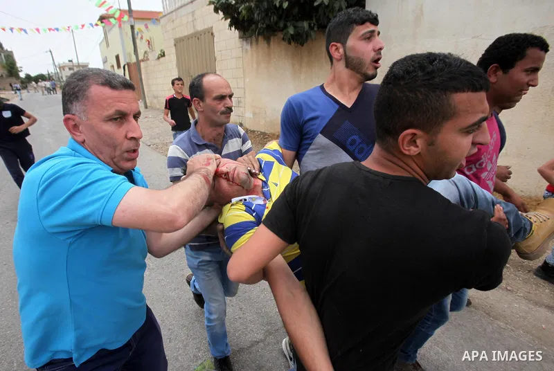 A wounded Palestinian is evacuated by protesters during clashes following a demonstration against the expropriation of Palestinian land by Israel, on May 13, 2016 in the village of Kfar Qaddum, near Nablus, in the occupi...
