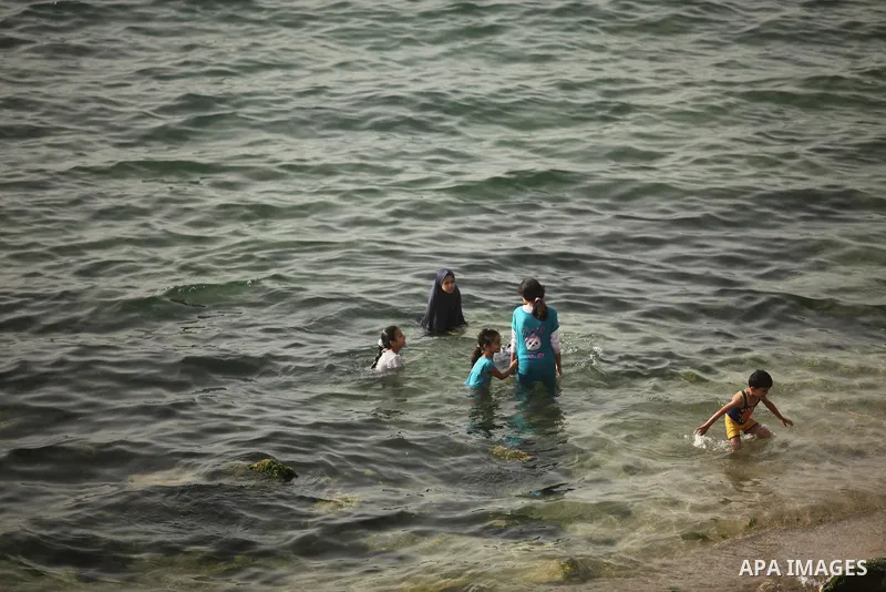 Palestinian children play in the water on the beach at the al-Shati refugee camp in Gaza City on May 14, 2016. Photo by Ashraf Amra