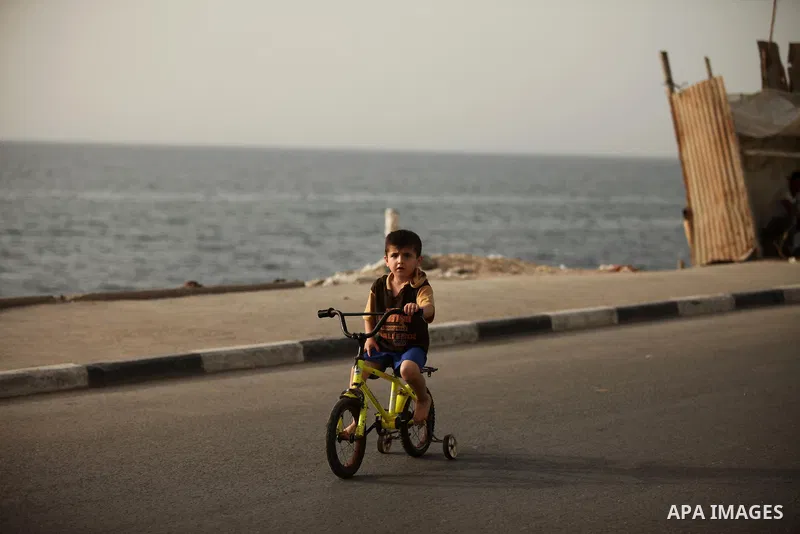 A Palestinian boy rides a bicycle at the al-Shati refugee camp in Gaza City on May 14, 2016. Photo by Ashraf Amra