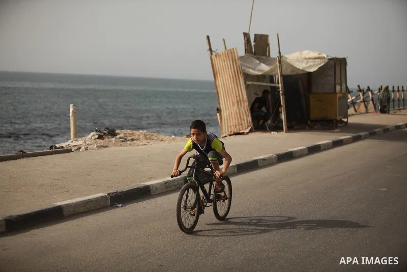 A Palestinian boy rides a bicycle on at the al-Shati refugee camp in Gaza City on May 14, 2016. Photo by Ashraf Amra