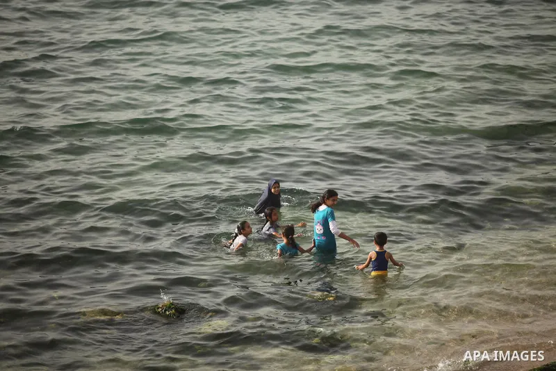 Palestinian children play in the water on the beach at the al-Shati refugee camp in Gaza City on May 14, 2016. Photo by Ashraf Amra