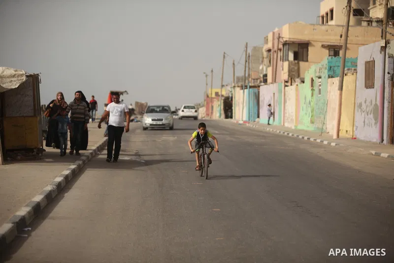 A Palestinian boy rides a bicycle on at the al-Shati refugee camp in Gaza City on May 14, 2016. Photo by Ashraf Amra