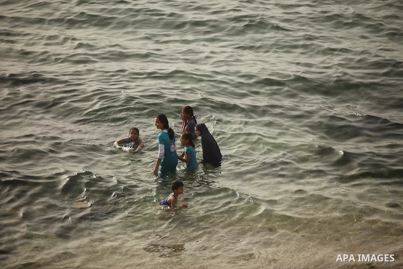 Palestinian children play in the water on the beach at the al-Shati refugee camp in Gaza City on May 14, 2016. Photo by Ashraf Amra