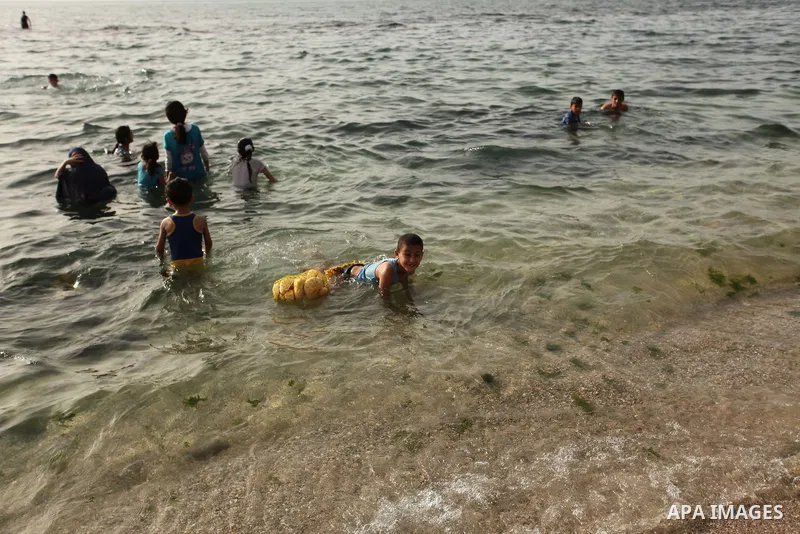 Palestinian children play in the water on the beach at the al-Shati refugee camp in Gaza City on May 14, 2016. Photo by Ashraf Amra