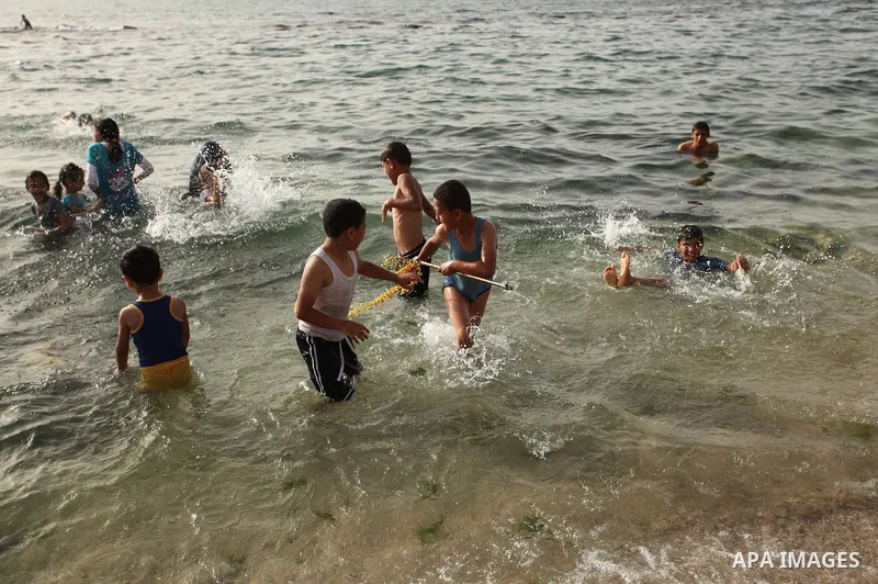 Palestinian children play in the water on the beach at the al-Shati refugee camp in Gaza City on May 14, 2016. Photo by Ashraf Amra