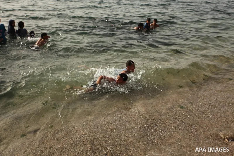 Palestinian children play in the water on the beach at the al-Shati refugee camp in Gaza City on May 14, 2016. Photo by Ashraf Amra