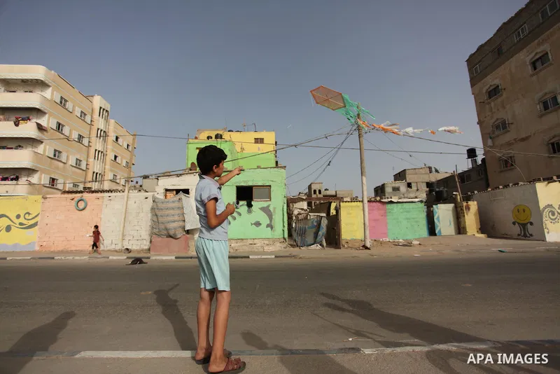 A Palestinian boy flies a kite on at the al-Shati refugee camp in Gaza City on May 14, 2016. Photo by Ashraf Amra