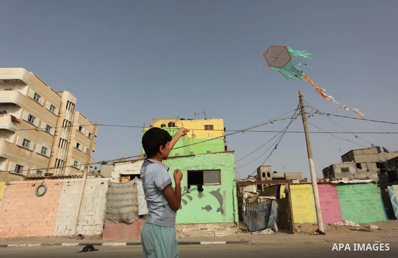 A Palestinian boy flies a kite on at the al-Shati refugee camp in Gaza City on May 14, 2016. Photo by Ashraf Amra