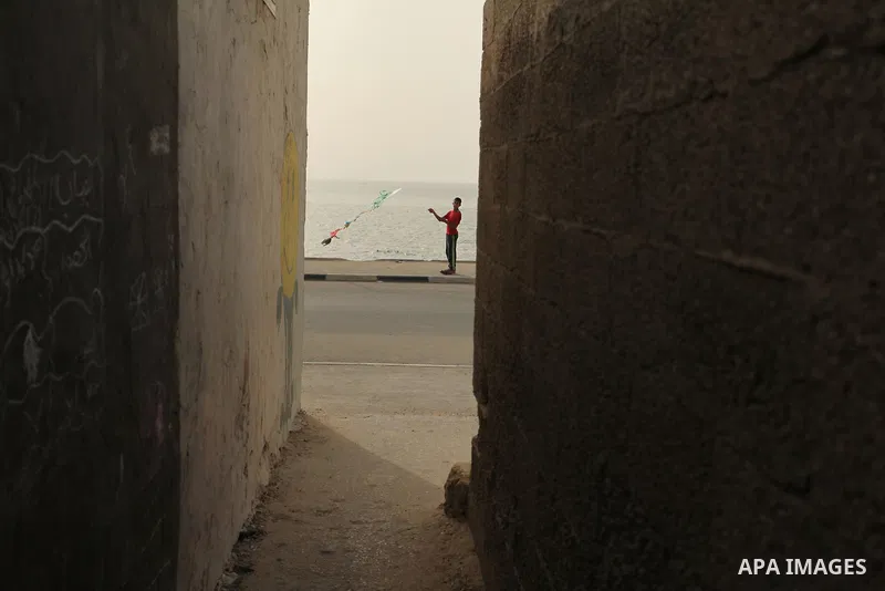 A Palestinian boy flies a kite on at the al-Shati refugee camp in Gaza City on May 14, 2016. Photo by Ashraf Amra