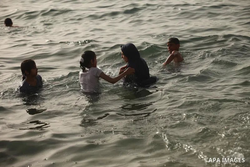 Palestinian children play in the water on the beach at the al-Shati refugee camp in Gaza City on May 14, 2016. Photo by Ashraf Amra