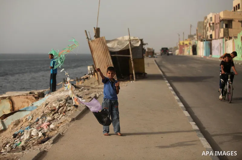 A Palestinian boy flies a kite on at the al-Shati refugee camp in Gaza City on May 14, 2016. Photo by Ashraf Amra