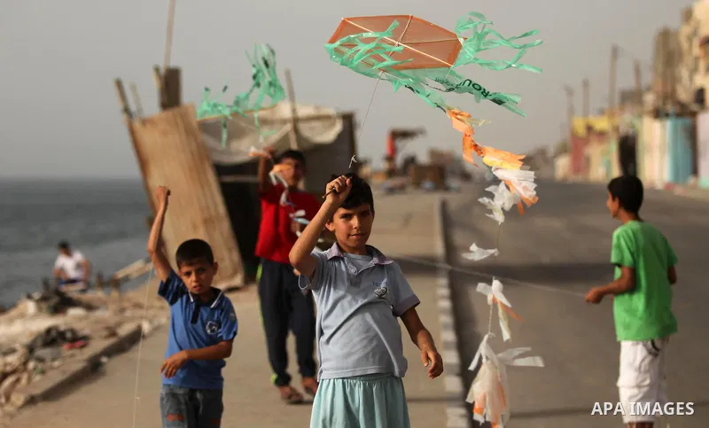 A Palestinian boy flies a kite on at the al-Shati refugee camp in Gaza City on May 14, 2016. Photo by Ashraf Amra