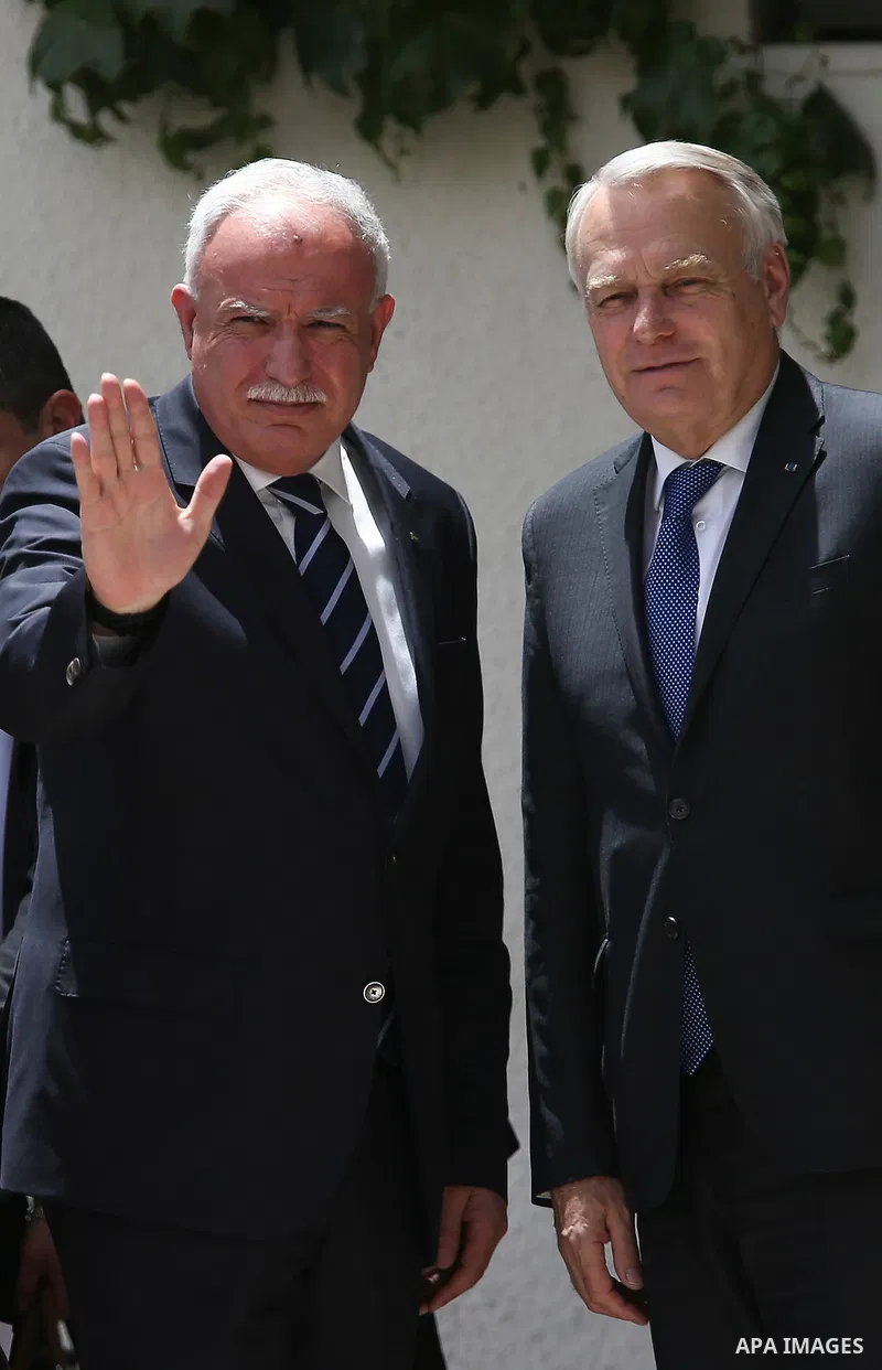 Palestinian Foreign Minister Riyad al-Maliki waves to media as French Foreign Minister Jean-Marc Ayrault (R) arrives to meet Palestinian President Mahmoud Abbas in the West Bank city of Ramallah May 15, 2016. apaimages/F...