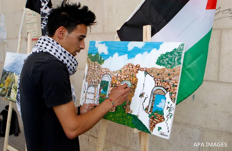 Palestinian artists paint artwork during a rally marking the 68th anniversary of the Nakba in the West Bank city of Hebron May 15, 2016. "Nakba" means in Arabic "catastrophe" in reference to the birth of the state of Isr...
