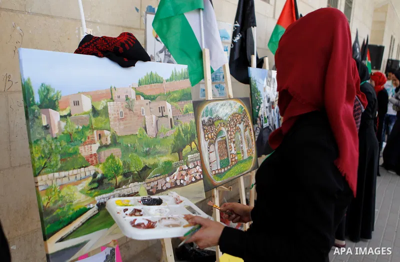 Palestinian artists paint artwork during a rally marking the 68th anniversary of the Nakba in the West Bank city of Hebron May 15, 2016. "Nakba" means in Arabic "catastrophe" in reference to the birth of the state of Isr...