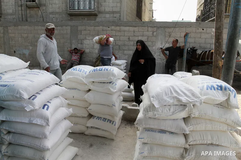 Palestinians refugees wait to receive aid at a distribution centre of the United Nations Relief and Works Agency (UNRWA) in the southern Gaza Strip town of Khan Younis on May 15, 2016, on the 68th anniversary of the "Nak...