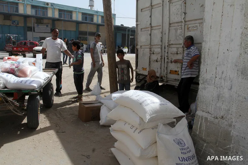 Palestinians refugees wait to receive aid at a distribution centre of the United Nations Relief and Works Agency (UNRWA) in the southern Gaza Strip town of Khan Younis on May 15, 2016, on the 68th anniversary of the "Nak...