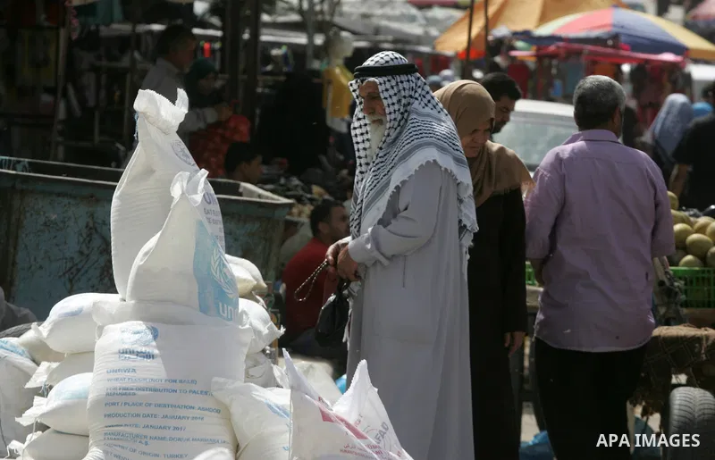 Palestinians refugees wait to receive aid at a distribution centre of the United Nations Relief and Works Agency (UNRWA) in the southern Gaza Strip town of Khan Younis on May 15, 2016, on the 68th anniversary of the "Nak...