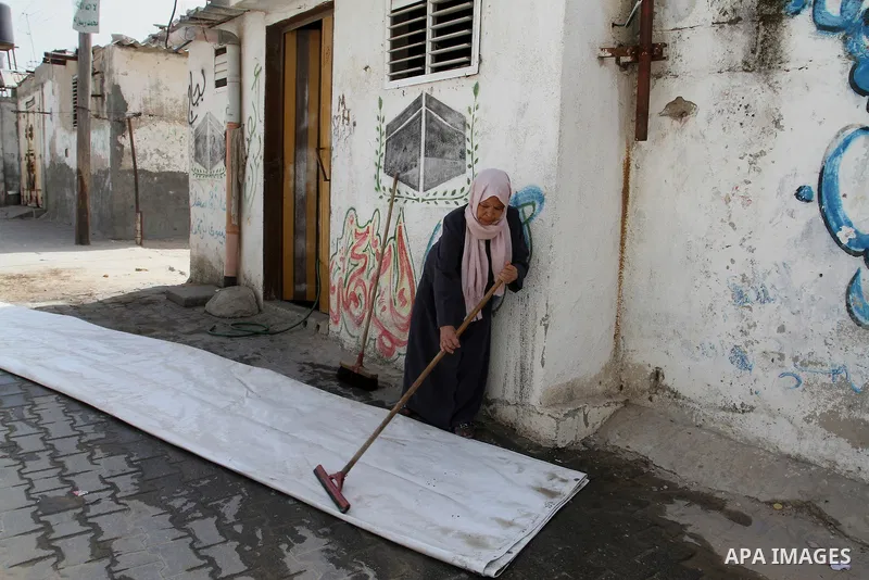 A Palestinian woman cleans outside her house on the 68th anniversary of the "Nakba" in the southern Gaza Strip town of Khan Younis on May 15, 2016. "Nakba" means in Arabic "catastrophe" in reference to the birth of the s...