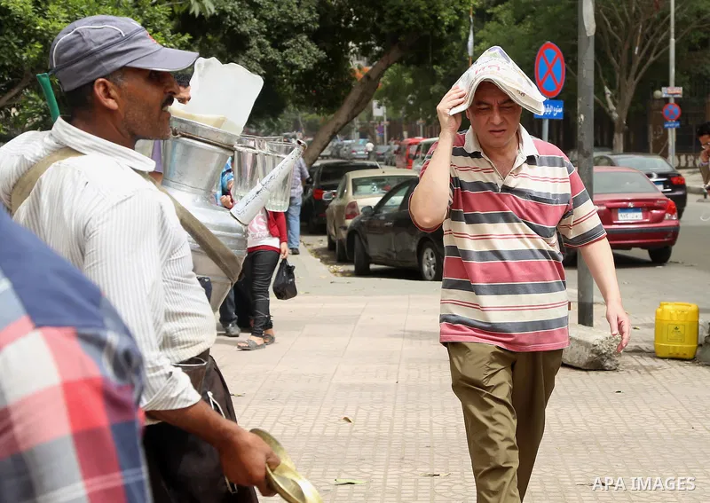 An Egyptian man uses a newspaper to cover his head from the sun during a sweltering heat wave, in Cairo, Egypt, on May 15, 2016. Photo by Amr Sayed