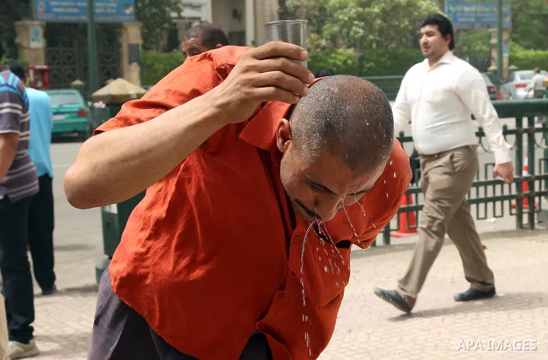 An Egyptian man reacts as he splashes water on his head during a sweltering heat wave, in Cairo, Egypt, on May 15, 2016. Photo by Amr Sayed