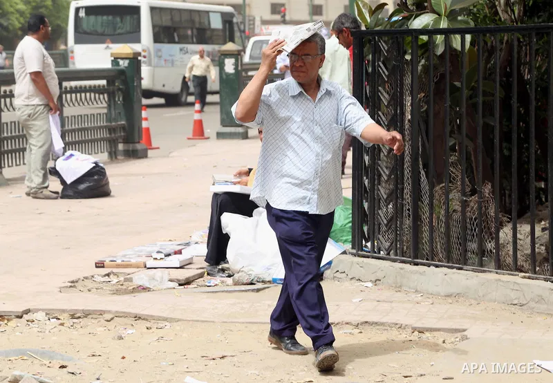An Egyptian man uses a newspaper to cover his head from the sun during a sweltering heat wave, in Cairo, Egypt, on May 15, 2016. Photo by Amr Sayed