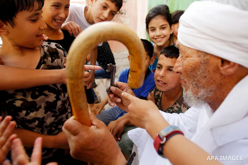A Palestinian man holds key symbolising the homes they left in 1948 in front of his house on the 68th anniversary of the "Nakba" in al-Fawar Palestinian refugee camp, south of the West Bank city of Hebron on May 15, 2016...