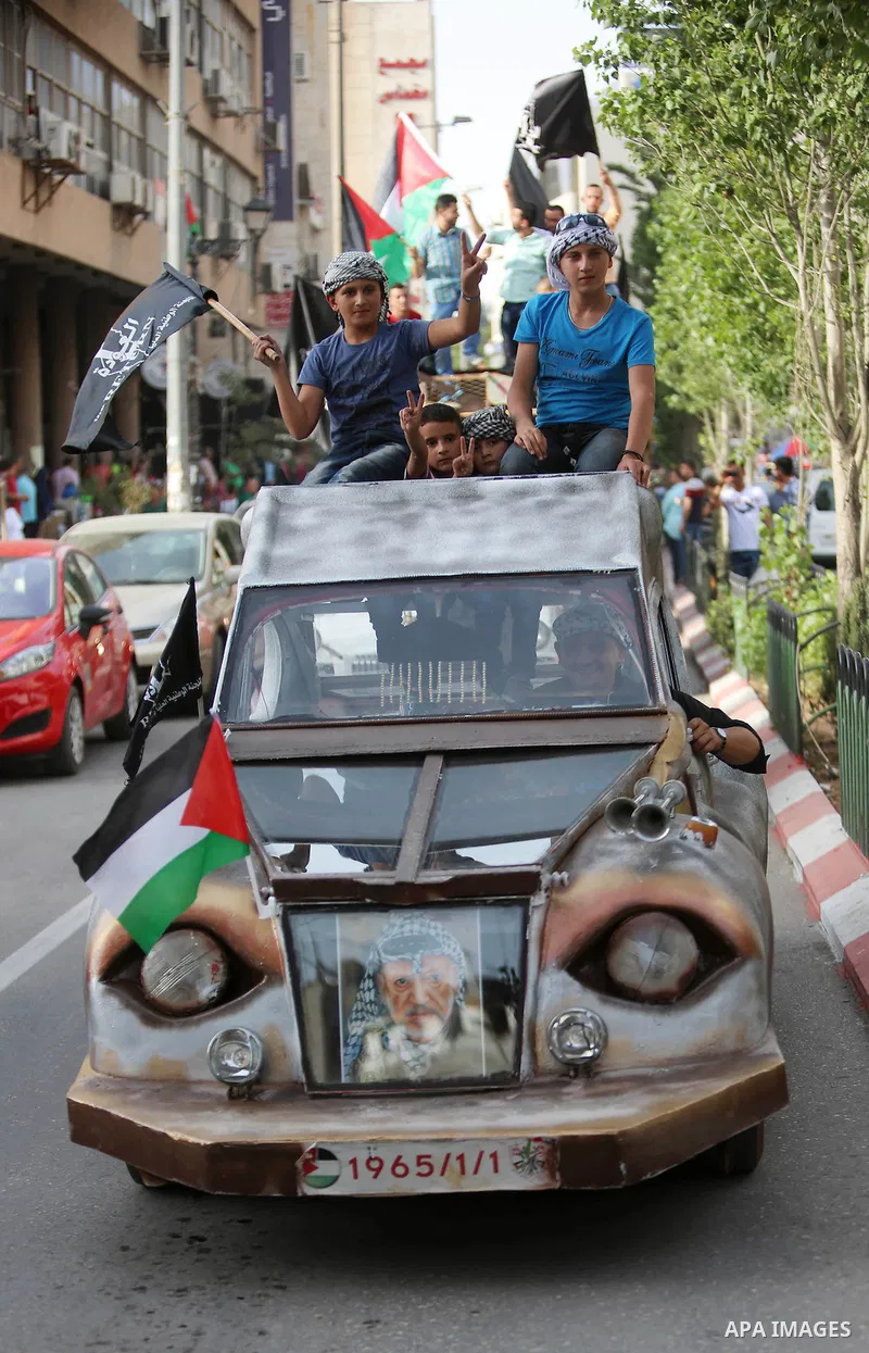 Palestinians ride an old vehicles and hold national flags in a procession on the 68th anniversary of the "Nakba" in the West Bank city of Ramallah on May 15, 2016. "Nakba" means in Arabic "catastrophe" in reference to th...