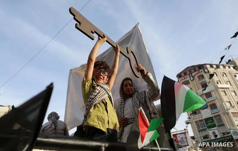 Palestinians ride an old vehicles and hold national flags in a procession on the 68th anniversary of the "Nakba" in the West Bank city of Ramallah on May 15, 2016. "Nakba" means in Arabic "catastrophe" in reference to th...