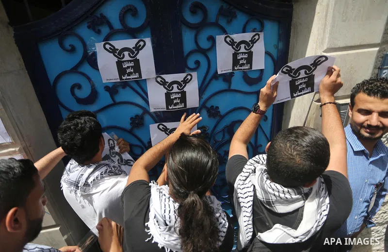 Palestinian activists of Intifada youth coalition, close the gate of "UNDP" during a protest to commemorate the "Nakba" or "catastrophe" in Arabic in reference to the establishment in 1948 of the state of Israel, in Gaza...