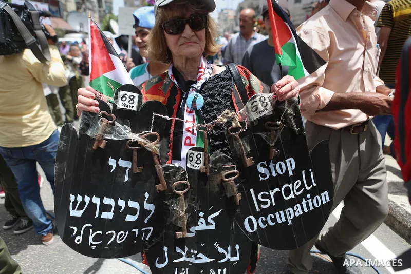 Palestinians hold a flag during in a procession on the 68th anniversary of the "Nakba" in the West Bank city of Ramallah on May 15, 2016. "Nakba" means in Arabic "catastrophe" in reference to the birth of the state of Is...
