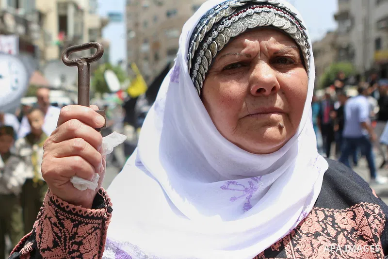 Palestinians hold a flag during in a procession on the 68th anniversary of the "Nakba" in the West Bank city of Ramallah on May 15, 2016. "Nakba" means in Arabic "catastrophe" in reference to the birth of the state of Is...
