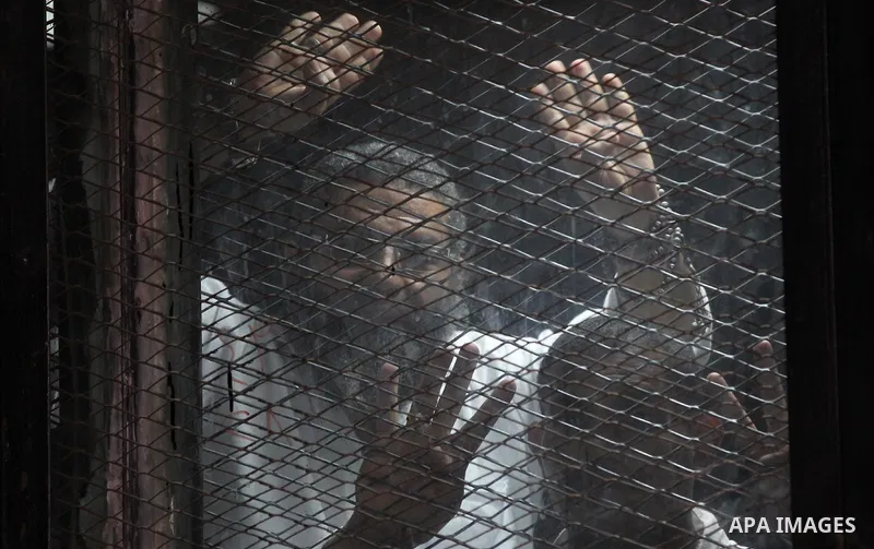 Egyptian Muslim Brotherhood members stand inside the defendants cage during their trial in the capital Cairo on May 17, 2016. Photo by Amr Sayed