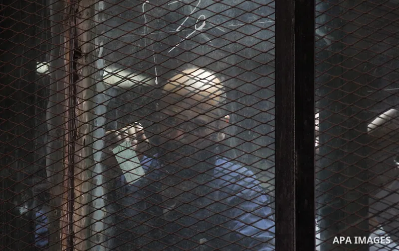 Egyptian Muslim Brotherhood members stand inside the defendants cage during their trial in the capital Cairo on May 17, 2016. Photo by Amr Sayed