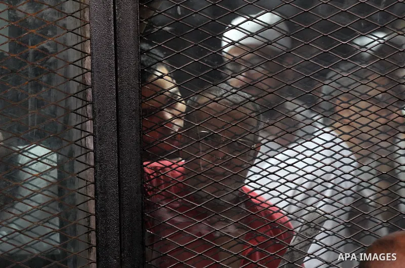 Egyptian Muslim Brotherhood members stand inside the defendants cage during their trial in the capital Cairo on May 17, 2016. Photo by Amr Sayed