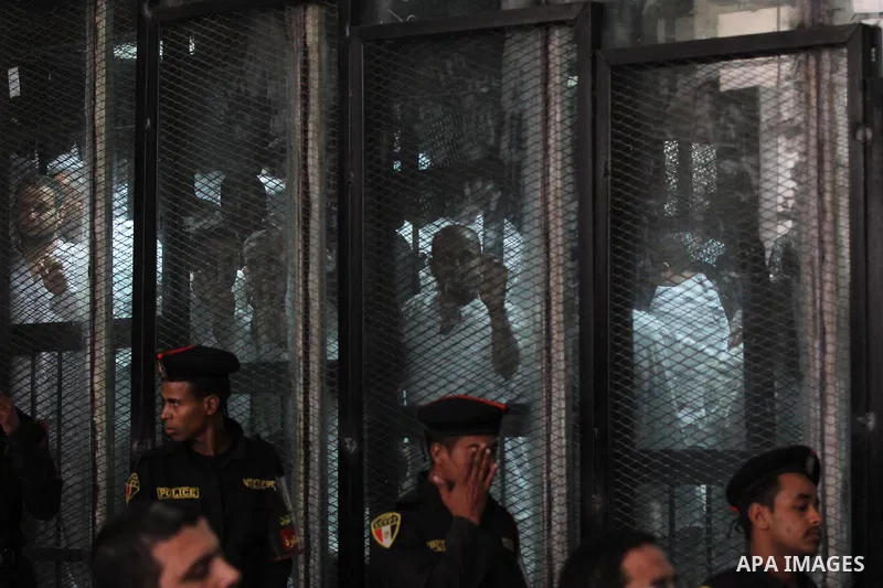 Egyptian Muslim Brotherhood members stand inside the defendants cage during their trial in the capital Cairo on May 17, 2016. Photo by Amr Sayed